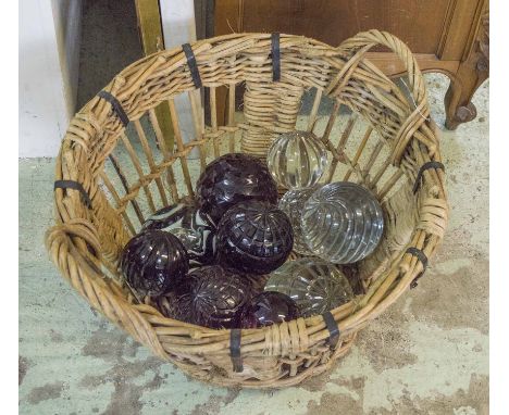 DOOR STOPS, a collection of ten, various spherical moulded clear and amethyst glass examples, and a wicker basket, largest 13