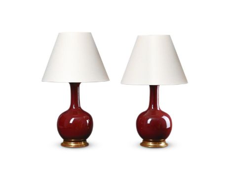 A PAIR OF CHINESE SANG DE BOEUF VASE TABLE LAMPS OF RECENT MANUFACTURE With giltwood bases and pale linen shades 82cm high to