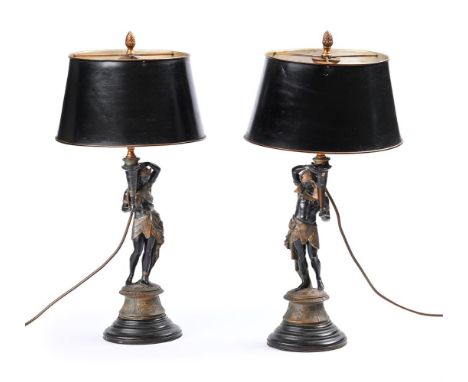A PAIR OF FRENCH PAINTED SPELTER EGYPTIAN FIGURAL TABLE LAMPS LATE 19TH OR EARLY 20TH CENTURY With tole lamp shades and eboni