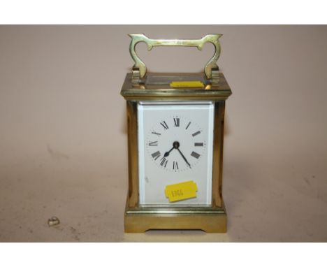 AN ANTIQUE BRASS AND GLASS CASED CARRIAGE CLOCK