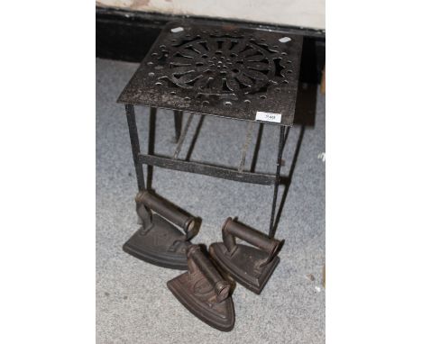THREE VINTAGE CAST METAL IRONS ON A CAST METAL TRIVET STAND, TRIVET STAND HEIGHT - 33CM
