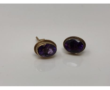 A pair of 9ct gold oval cut amethyst earrings with post fittings. CONDITION REPORT: 1.1g