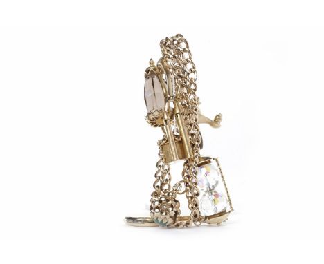 NINE CARAT GOLD CHARM BRACELETformed from a necklace, each link marked for nine carat gold, with various charms including a g