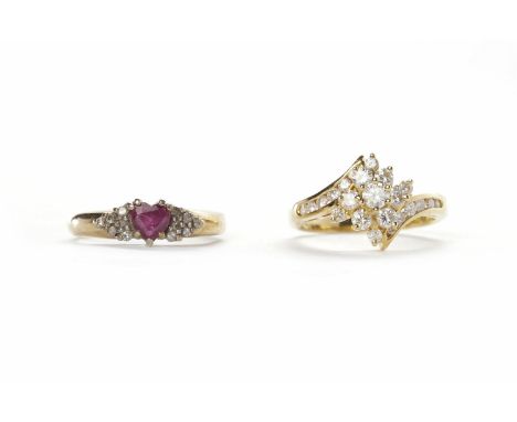 RUBY AND DIAMOND RINGthe central heart shaped ruby flanked by two clusters of round diamonds, in nine carat gold measuring si