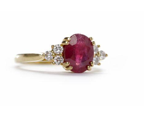 EIGHTEEN CARAT GOLD RUBY AND DIAMOND RING hallmarked 750, set with an oval ruby 8.47mm long and flanked by three round brilli