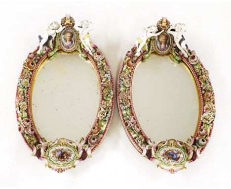 A large pair of Dresden oval mirrors,late 19th century, in the Meissen style, each surmounted by two putti and an oval portra