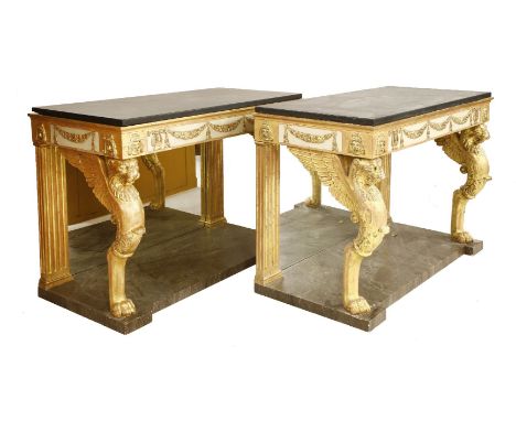 A pair of gilt console tables,in the Empire style, with plain slate tops, cream and gilt with swags, harps and masks, and a m