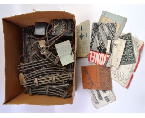 LIONEL TRAINS; A box of vintage Lionel 0 gauge branded railway trainset track, transformers, instruction manuals and other ac