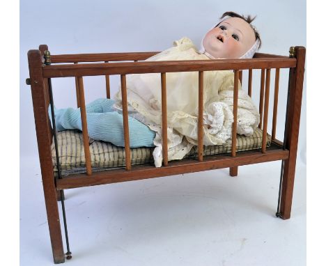 JUTTA DOLL & CRIB; An antique Jutta Baby ceramic headed doll marked 1922 to rear of head, along with an associated wooden dol
