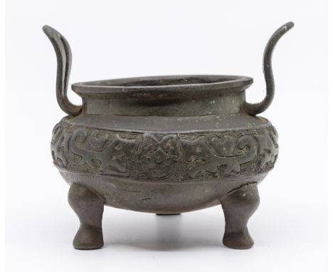   A 19th century Chinese bronze censor, twin handled and three footed, impressed circular stamp to base, approx. 12cm high.