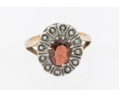 A garnet and seed pearl 9ct gold oval ring, size H1/2, total gross weight approx 2.4gms in an antique retailers box   Further