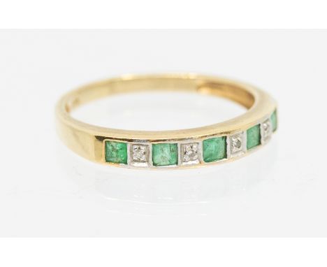An emerald and diamond d set half eternity ring, comprising alternate square cut emeralds and grain set round brilliant cut d