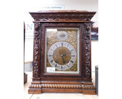 An elaborately carved oak cased bracket clock, with gilt decoration surrounding face, stylised design. Untested