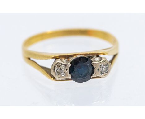A diamond and sapphire three stone 18ct gold ring, comprising a round mixed cut sapphire to the centre, within star set diamo