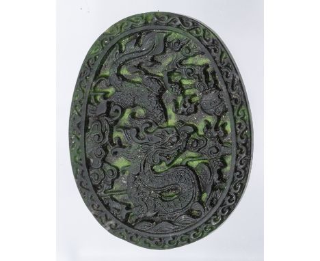 A Chinese spinach jade carved oval panel, carved in shallow relief with a dragon and ornate decoration,  length approx 52 x 4