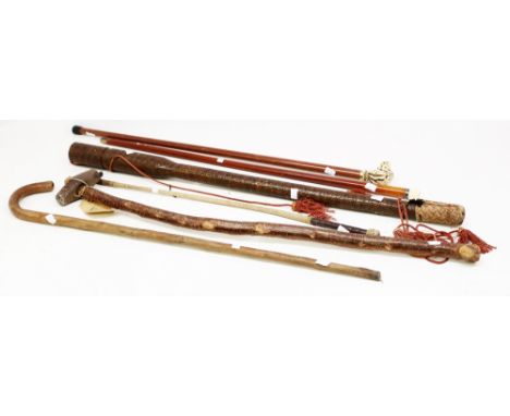 A collection of walking sticks, whips, arrow quivers and an early 20th Century hammer, to break up stone.