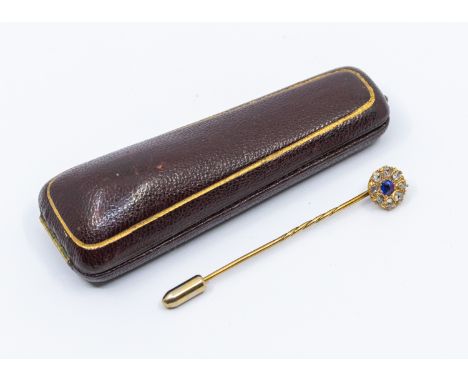 A cased Victorian/Edwardian sapphire and diamond yellow metal stick pin, comprising a circular cluster set to the centre with