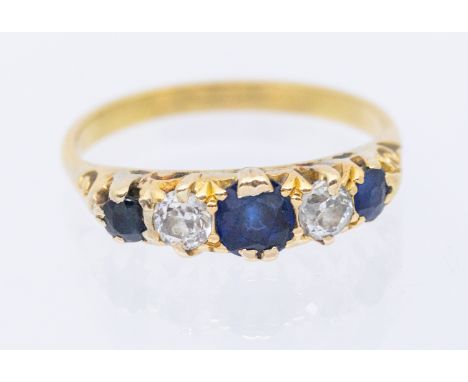 A sapphire and diamond five 18ct gold ring, width approx 4mm, size O1/2, unmarked assessed as 18ct gold, total gross weight a