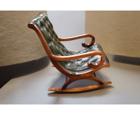A 20th Century bottle green button back mahogany and leatherette rocking chair.