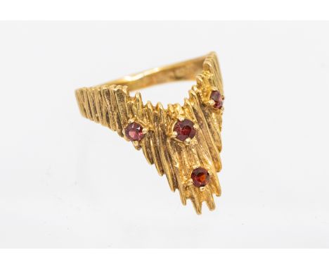 A garnet and 9ct gold textured wishbone ring, set with round mixed cut garnets, width approx 18mm, size P1/2, London 1975, to