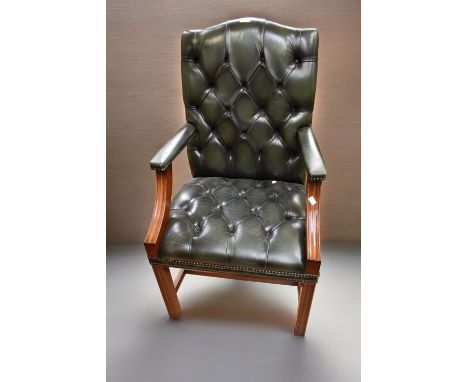 A 20th Century bottle green with button back hall arm chair on block legs, mahogany and leatherette.&nbsp;