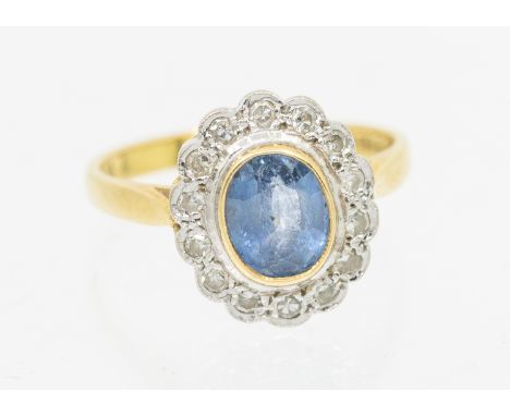 A sapphire and diamond 18ct gold ring, comprising a central rub over set oval mixed cut sapphire approx 7 x 5.5mm, within a s
