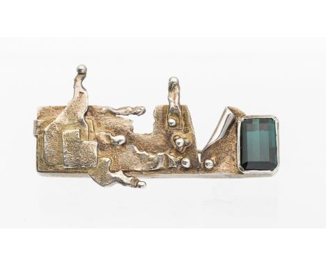 Modernist silver and Indicolite tourmaline brooch, comprising layered silver decoration rub over set with a emerald cut tourm