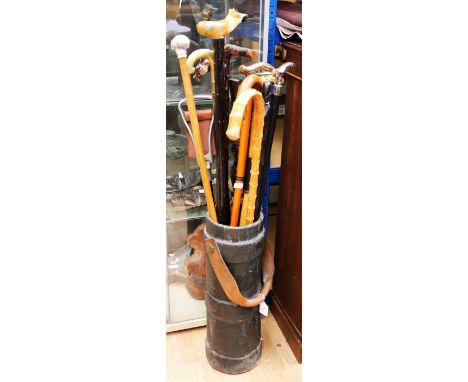 A leather shell outer case with swing handle, now a stick stand, along with various 20th century or modern sticks /&nbsp; can