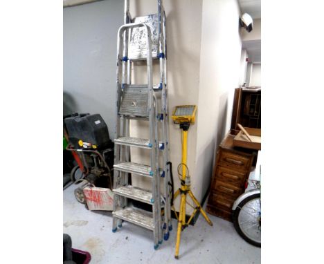 Two sets of aluminium folding ladders together with a site light on stand  CONDITION REPORT: Lot 622 - 653 are items found in