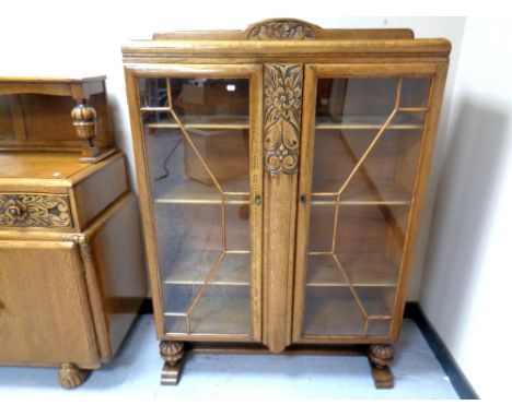 A 1930's carved oak glazed bookcase 