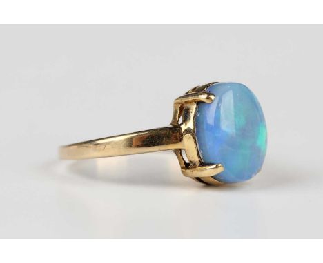 A gold ring, claw set with an oval opal, detailed ‘18K’, weight 3.2g, ring size approx K1/2, with a case.