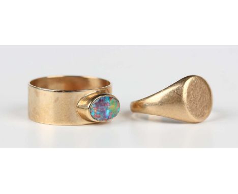 A gold ring mounted with an oval opal doublet, detailed ‘9ct’, ring size approx N, and a 9ct gold oval signet ring, London 19