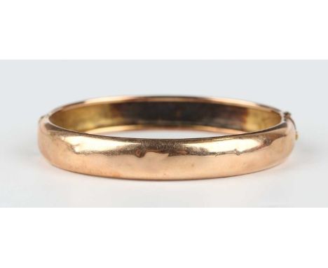 A gold oval hinged bangle, unmarked, weight 12.9g, inside width 5.7cm.