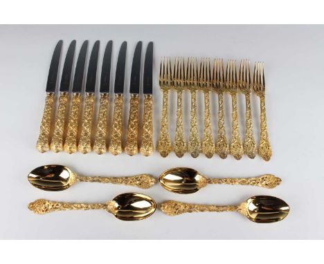 An Elizabeth II part canteen of silver gilt cutlery, pierced and cast with naturalistic entwined stems of fruiting vines, com