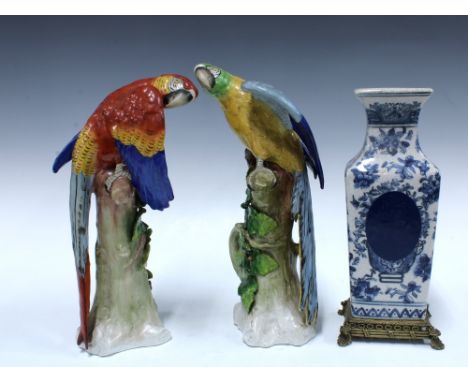Two Sitzendorf parrots, taller 31cm, together with a blue and white vase on a brass mount, a/f (3)