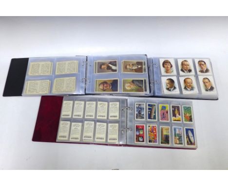 Three albums containing trade and cigarette card sets including some oversized cards from Brooke Bond, Wills, Platers, Amaran