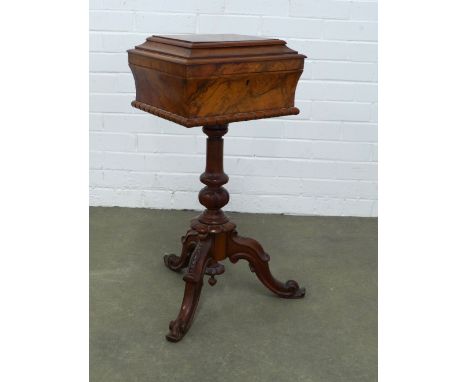 19th century walnut and mahogany teapoy, sarcophagus top with a fitted interior, on pedestal base with three outswept carved 