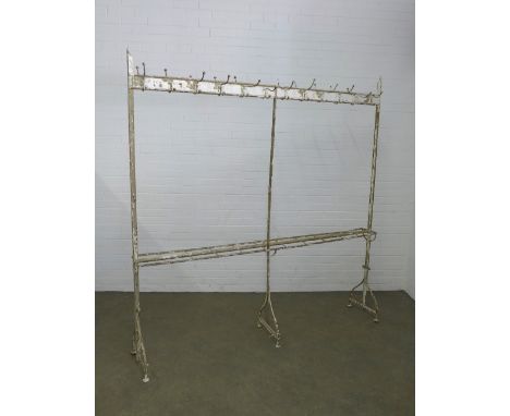 An early 20th century free standing painted metal hall stand of large proportions, the top with double sided coat hooks and t