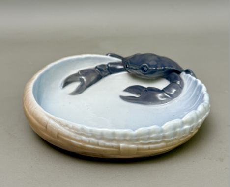 A Royal Copenhagen 3131 dish - modelled as a crab climbing into a shallow basket, painted factory marks, 16cm wide.