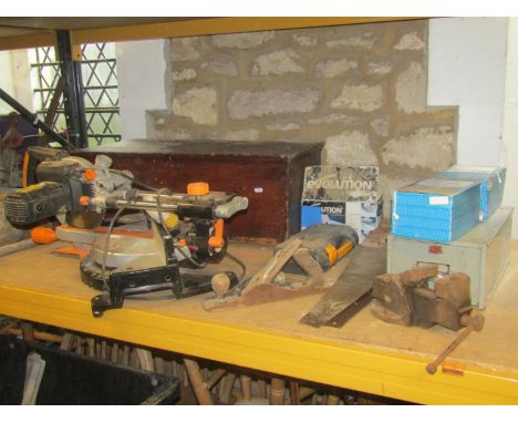 An Evolution electric multi purpose sliding mitre saw together with a box of miscellaneous tools, including hand saws, a few 