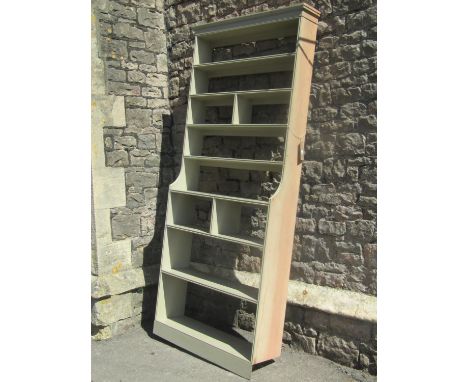 A freestanding light green painted pine bookcase/shelving unit, with fixed and segmented shelves with moulded outline, approx
