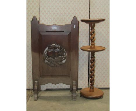 An arts and crafts style oak firescreen, the chamfered frame enclosing a rectangular fielded panel, with central pierced roun