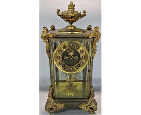 French brass and ormolu four glass mantel clock in the rococo manner, with scrolled fittings mounted by a campana urn, unusua