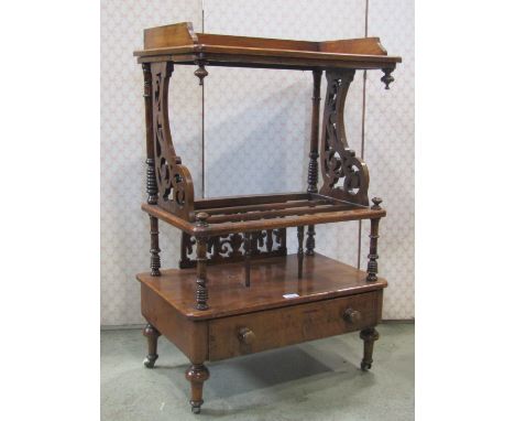 A Victorian walnut veneered three divisional Canterbury whatnot, with pierced scrolling side brackets and ring turnings over 
