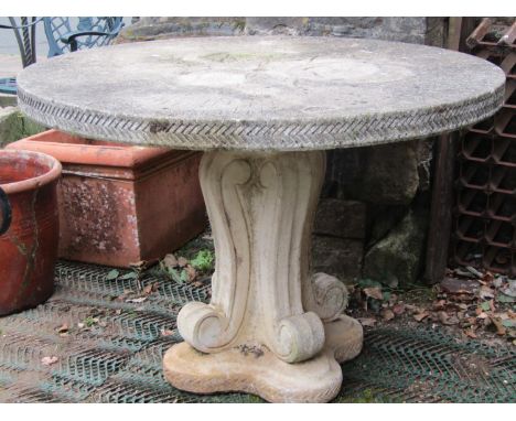 A reclaimed garden table, the circular top with foliate detail and chevron border, raised on a scrolled pedestal, 115cm diame