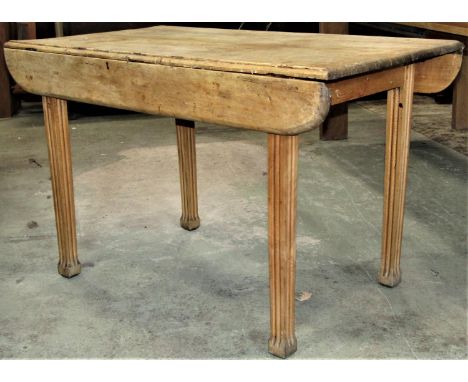 An unusual light stained beechwood kitchen table of rectangular form, with short drop leaves and moulded outline raised on fo