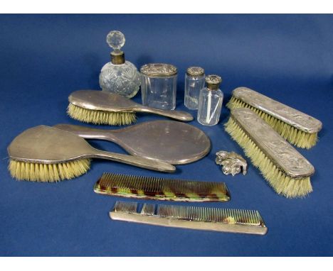 A box containing a collection of dressing set items comprising four brushes, four lidded bottles, a silver topped comb and on