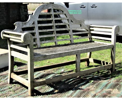 A weathered teak Lutyens style three seat garden bench 165 cm long (weathered splits to scrolled arms and framework) 