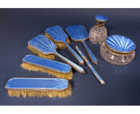 A collection of silver and guilloche enamel dressing set items comprising four brushes, a mirror, two lidded glass jars and a
