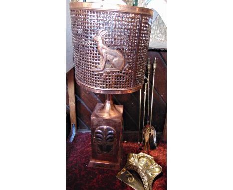 An unusual possibly African copper floor lamp, with geometric pierced shade embossed with animals and flower over a stepped s